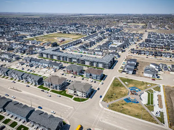 Ortasında park olan bir şehir caddesi. Park evlerle çevrili ve bir oyun alanı var.