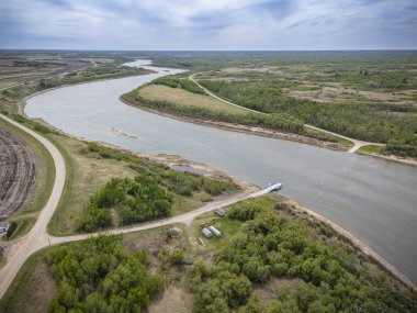 Kıyısında yeşil orman olan bir nehir. Su sakin ve gökyüzü bulutlu.