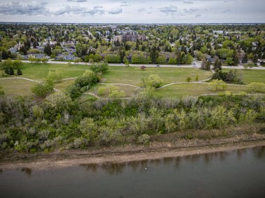 İçinden nehir akan bir şehir manzarası. Nehir ağaçlarla çevrili ve şehir arka planda.