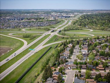 Arka planda çevre yolu olan bir şehir sokağı. Çevre yolu trafiğin yoğun olduğu dört yollu bir kavşaktır.