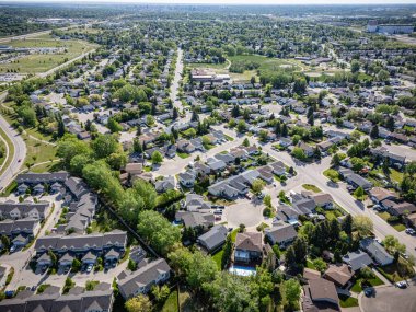 Evleri ve birkaç arabası olan bir yerleşim yeri. Evlerin çoğu beyaz ve arabalar caddeye park edilmiş.