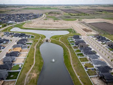 İçinden nehir akan bir yerleşim bölgesinin manzarası. Evlerin hepsi nehir boyunca dizilmiştir ve ortasında büyük bir su kütlesi vardır. Evlerin hepsi farklı boyutlarda.