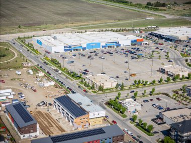 Büyük Walmart mağazası bir otoparkla çevrilidir. Otopark araba dolu ve otoparkta park edilmiş birkaç kamyon var. Meşguliyet ve faaliyet kavramı