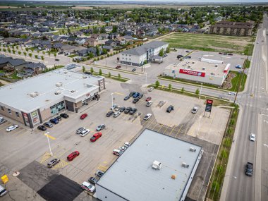 Arka planda büyük bir bina olan park yeri. Otopark araba ve kamyonlarla dolu.