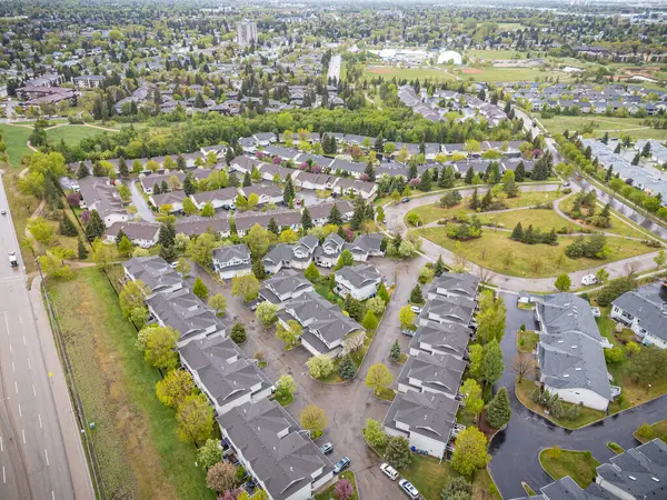 Birçok evi ve birkaç arabası olan bir yerleşim yeri. Evlerin çoğu beyaz ve arabalar garaj yolunda park halinde.