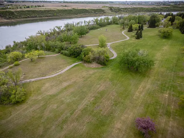 İçinden nehir akan büyük çimenli bir arazi. Çimler yeşil, ağaçlar kahverengi.