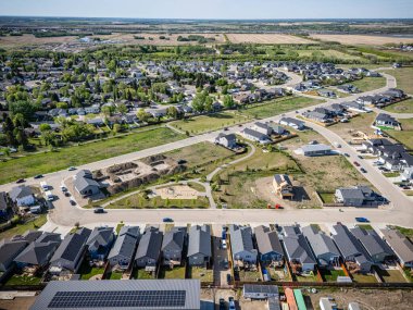 Birçok evi ve birkaç arabası olan bir yerleşim yeri. Evlerin çoğu beyaz ve arabalar caddeye park edilmiş.