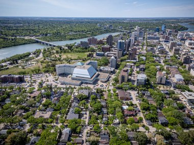Şehir manzarası yukarıdan, ortada büyük bir bina var. Şehir ev ve arabalarla dolu.