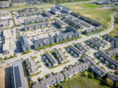 Bir sürü evi ve birkaç arabası olan bir yerleşim yeri manzarası. Evlerin çoğu beyaz ve arabalar otoparka park edilmiş.