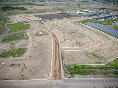 Yan tarafında çit olan kirli bir yol. Yol bir tarlanın ortasında.
