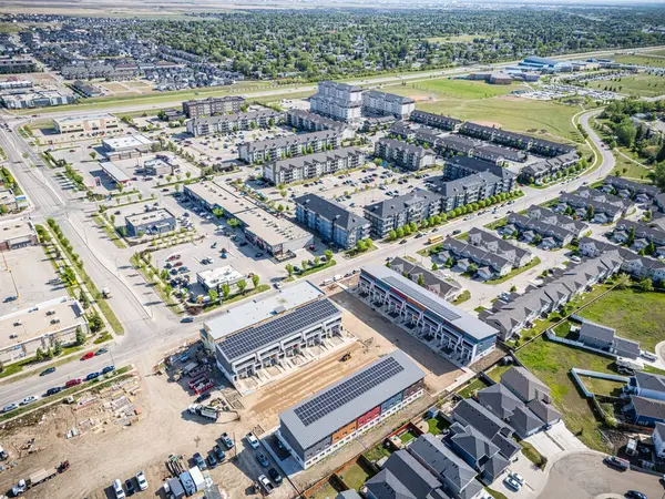 Arka planda büyük bir apartman kompleksi olan şehir caddesi. Sokaklar park etmiş arabalar ve birkaç kamyonla dolu.