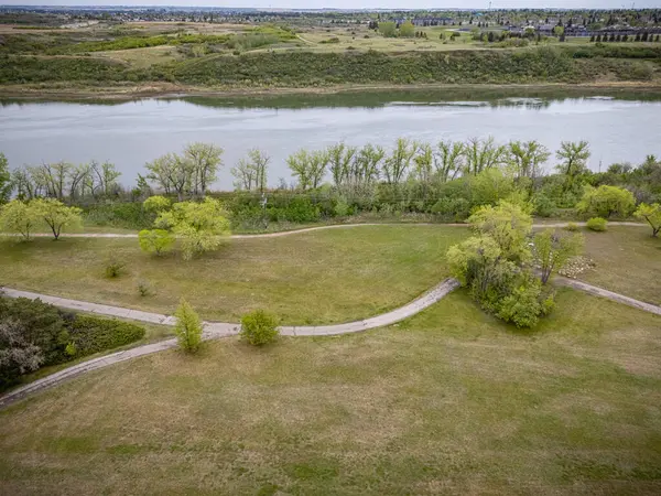 İçinden nehir akan otlak bir alan. Nehir sakin ve ağaçlar yeşil.