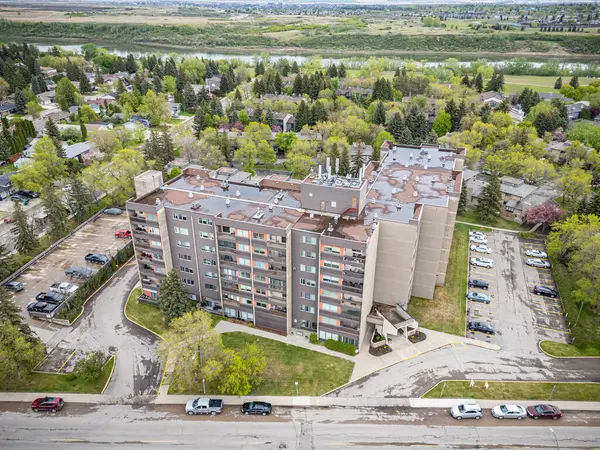 Önünde park yeri olan büyük bir apartman. Otopark birkaç kamyon da dahil olmak üzere arabalarla dolu. Görüntüde bir meşguliyet ve aktivite duygusu var, insanların gelmesi muhtemel.