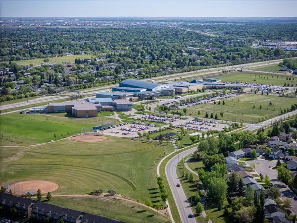 Beyzbol sahası ve arka planda birkaç ev. Evlerin hepsi yol boyunca dizilmiş.