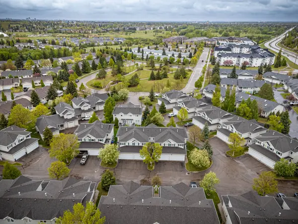 Birçok evi ve birkaç arabası olan bir yerleşim yeri. Evler çoğunlukla gri ve gökyüzü bulutlu.
