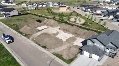 Bir sürü kir ve arka planda bir ev olan bir yerleşim yeri. Toprak birikti ve ev görüntünün sağ tarafında.