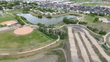 Beyzbol sahası ve toprak pisti olan bir park. Beyzbol sahası çitlerle çevrili ve toprak pist parkın ortasında.