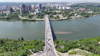 Üzerinde arabalar olan bir nehir üzerinde köprü. Köprü çok uzun ve nehir boyunca uzanıyor.