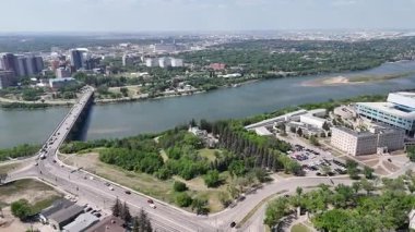 Şehir manzarası ve içinden bir nehir geçiyor. Binalar yüksek ve gökyüzü mavi.