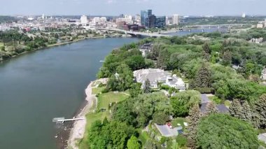 Üzerinden nehir akan ve üzerinde köprü olan bir şehir. Nehir yeşil ve köprü beyaz.
