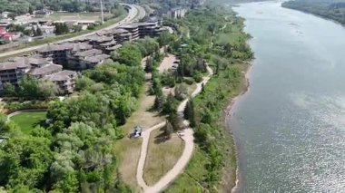 Sahilde yeşil ormanı olan bir nehir manzarası. Nehir sakin ve ağaçlar gür.