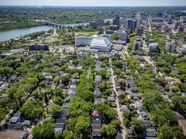 Şehir manzarası yukarıdan, içinden bir nehir akıyor. Evlerin çoğu yeşil ve arka planda birkaç bina var.