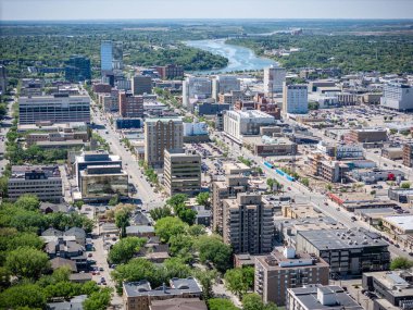 Şehir manzarası yukarıdan, içinden bir nehir akıyor. Şehir yüksek binalar ve arabalarla dolu.