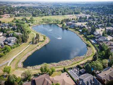 Büyük su kütlesi evler ve ağaçlarla çevrilidir. Su sakin ve huzurlu. Etrafına evler yayılmış.
