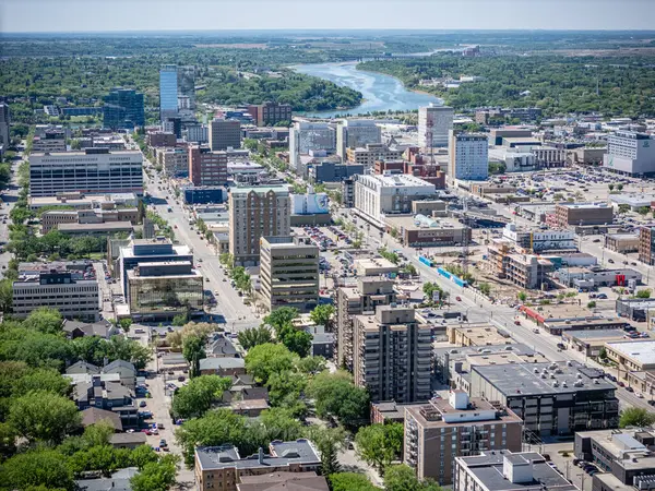 Şehir manzarası yukarıdan, içinden bir nehir akıyor. Şehir yüksek binalar ve arabalarla dolu.