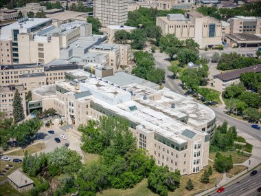 Bir sürü penceresi ve beyaz çatısı olan büyük bir bina. Bina ağaçlarla çevrili ve o bir hastane.