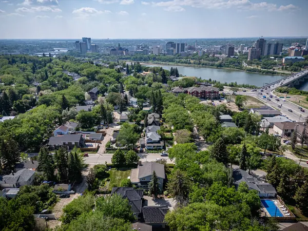 Şehir manzarası yukarıdan, arka planda bir göl var. Evler küçük ve sokaklar ağaçlarla dolu.
