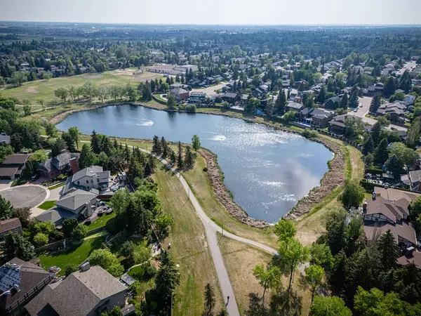 Ortasında büyük bir göl olan yerleşim yeri manzarası. Göl evler ve ağaçlarla çevrili.