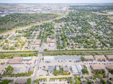 Şehir manzarası yukarıdan, bir sürü ev ve araba var. Evlerin çoğu beyaz ve arabalar park halinde.