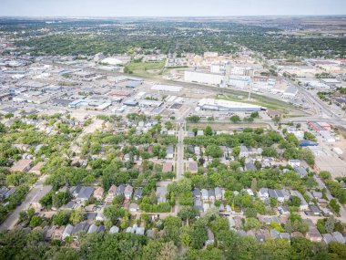 Şehir manzarası yukarıdan evler ve ağaçlarla çevrili. Evler çoğunlukla beyaz ve ağaçlar yeşil.