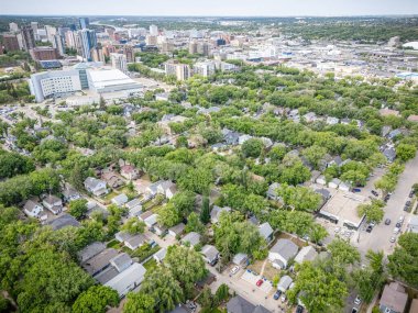 Şehir manzarası yukarıdan birçok ev ve ağaçla dolu. Evler çoğunlukla beyaz ve ağaçlar yeşil.