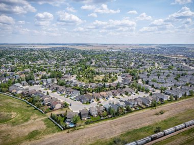 Şehir manzaralı, arka planda bir sürü ev ve tren var. Tren görüntünün sağ tarafında.