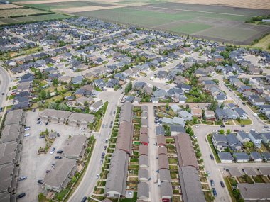 Birçok evi ve arabası olan bir yerleşim yeri. Evler çoğunlukla beyaz ve arabalar çoğunlukla mavi.