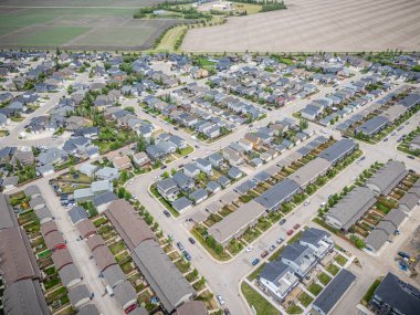 Birçok evi ve arabası olan bir yerleşim yeri. Evler çoğunlukla beyaz ve arabalar çoğunlukla mavi.