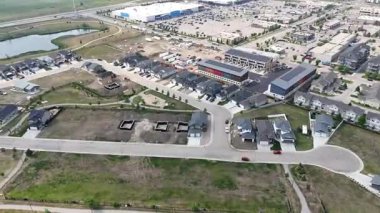 Evleri ve birkaç arabası olan bir yerleşim yeri manzarası. Evlerin çoğu beyaz ve cadde ağaçlarla kaplı.