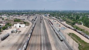 Üzerinde bir sürü tren olan tren rayı. Trenlerin hepsi siyah. Gökyüzü mavi
