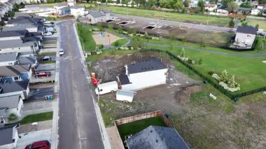 Önünde bir ev ve kamyon olan bir yerleşim yeri. Kamyon bir çöp kutusu taşıyor.