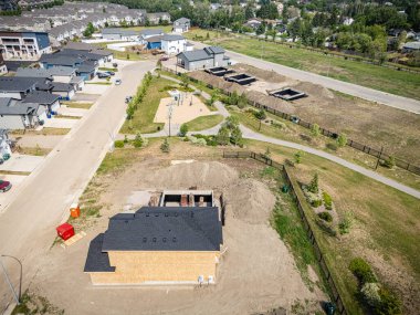 İnşaat halindeki bir evi olan bir yerleşim yeri. Ev görüntünün sağ tarafında.
