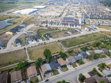 Evleri ve birkaç arabası olan bir yerleşim yeri. Evlerin çoğu beyaz ve arabalar caddeye park edilmiş.