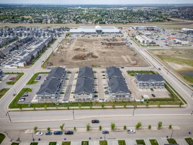 Çok sayıda evi ve alışveriş merkezi olan bir yerleşim yeri manzarası. Evlerin çoğu beyaz ve alışveriş merkezi arka planda.