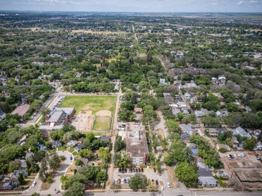 Şehir manzarası yukarıdan, önünde bir park ve bir okul var. Park evlerle çevrilidir ve okul parkın ortasında yer almaktadır. Evler dağıtıldı.