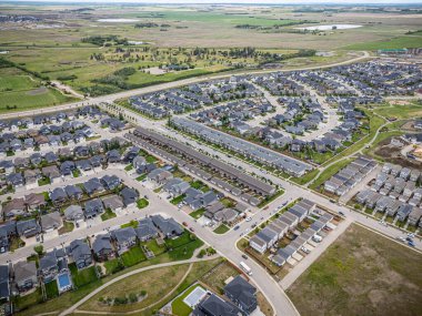 Evleri ve birkaç arabası olan bir yerleşim yeri. Evlerin çoğu beyaz ve cadde ağaçlarla kaplı.