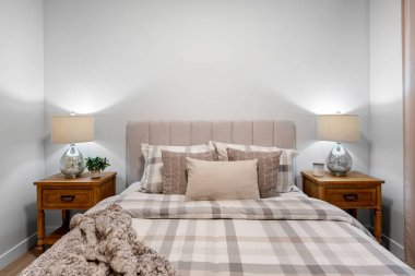 Yatak beyaz bir yorgan ve ekose desenli. Yatağın iki tarafında da iki tane komodin var ve her komodinin üzerinde de bir lamba var. Oda aydınlık ve rahat.