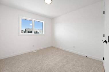 Penceresi ve kapısı olan beyaz bir yatak odası. Oda boş ve minimalist bir görünüşü var.