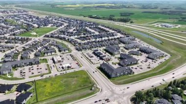 Bir sürü penceresi ve camında arabaların yansıması olan büyük bir bina. Bina içinde birçok arabanın park edildiği bir otoparkla çevrili.