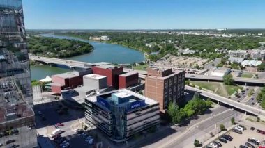 Bir sürü penceresi ve camında arabaların yansıması olan büyük bir bina. Bina içinde birçok arabanın park edildiği bir otoparkla çevrili.